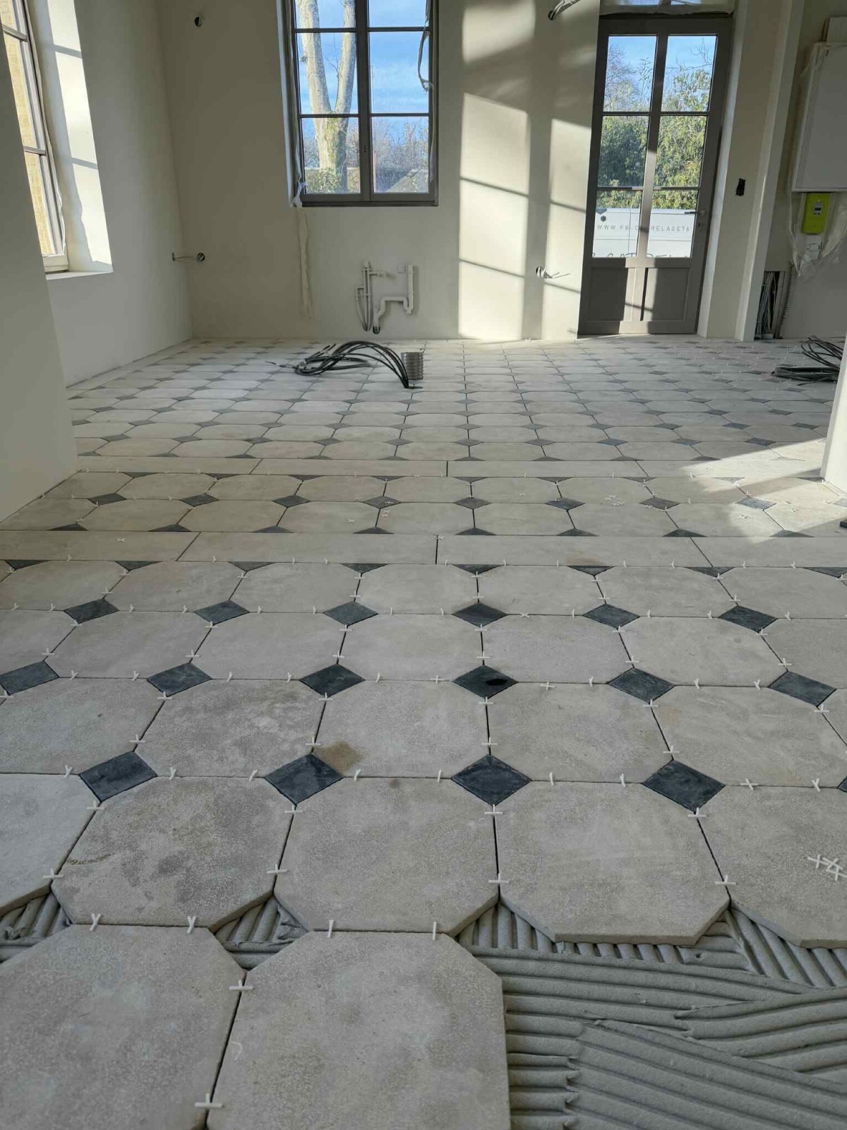Pose de carrelage au sol en octogones avec cabochons blancs et noir par des carreleurs qualifiés proche de Rouen 76 - TK Carrelage